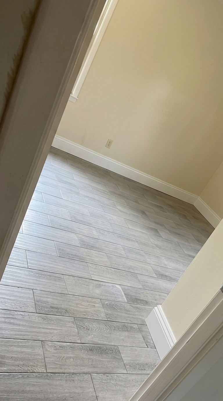 Waverly GA room with new gray wood-look tile flooring and fresh white baseboard trim installed