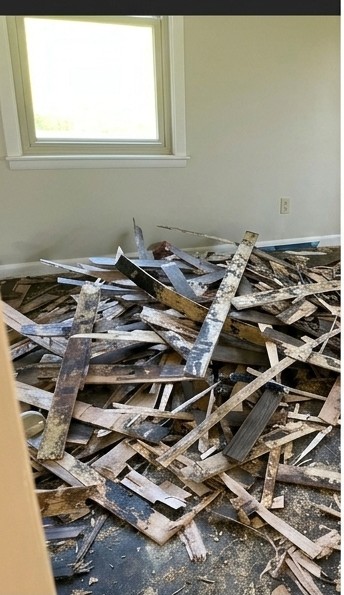 Waverly GA room with the old flooring torn out and debris piled on the bare subfloor before new tile
